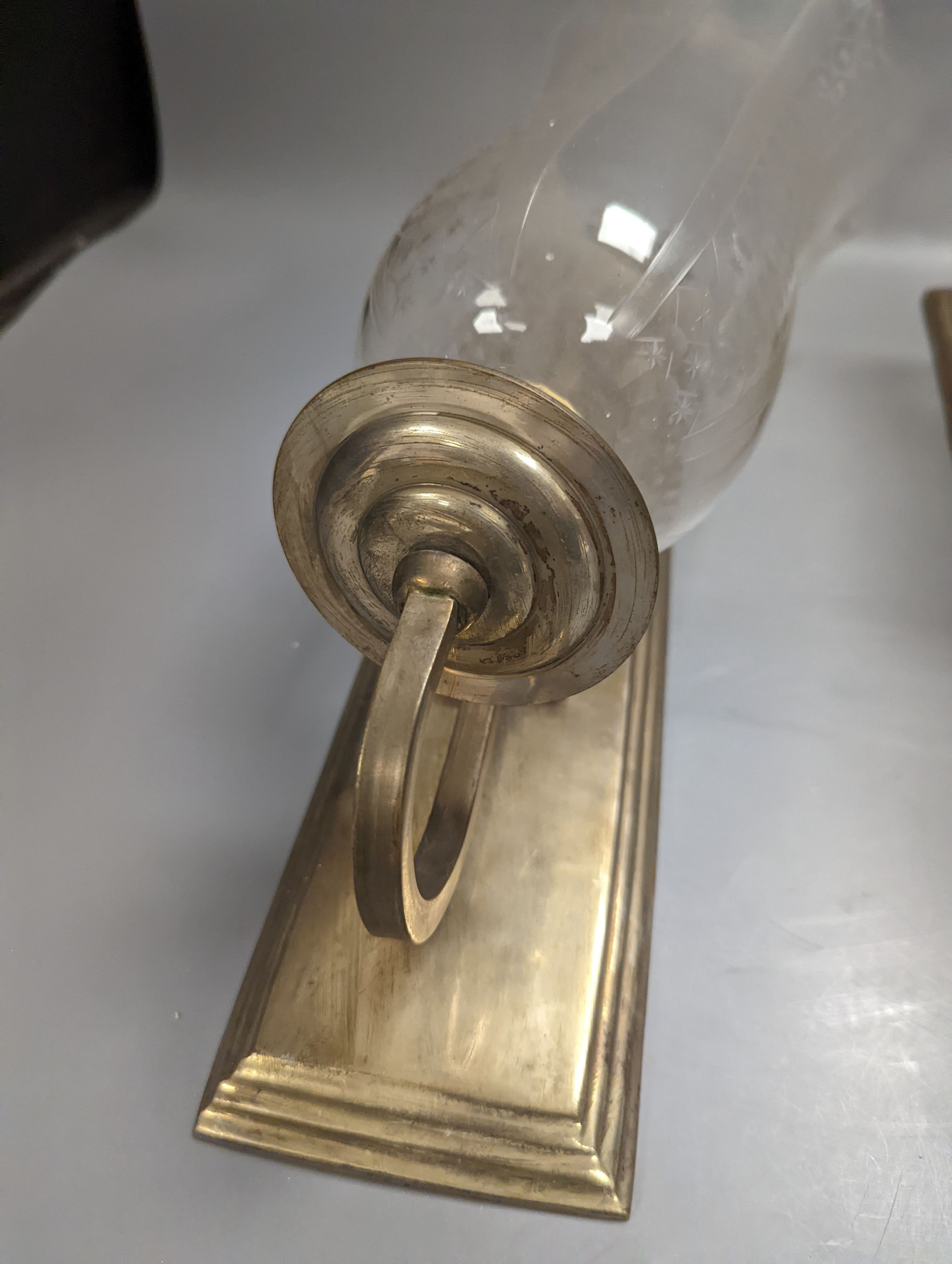 A pair of brass wall lights, with engraved glass storm shades, height 44cm